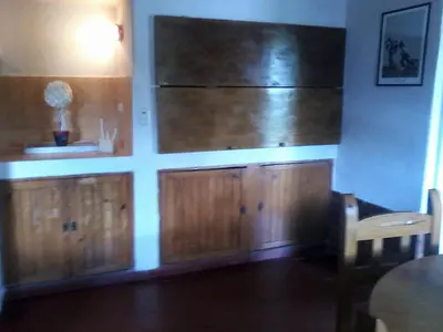 a kitchen with wooden cabinets and a large refrigerator at Aires de San Antonio in San Antonio de Arredondo