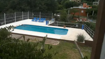 a swimming pool with blue chairs next to a fence at Aires de San Antonio in San Antonio de Arredondo