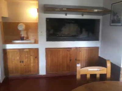 a kitchen with wooden cabinets and a flat screen tv at Aires de San Antonio in San Antonio de Arredondo