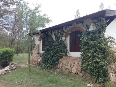 a house covered in ivy with a stone wall at Luna Azul in Nono