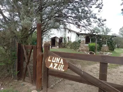 a wooden fence with a sign in front of a house at Luna Azul in Nono