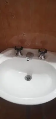 a white sink with two knobs on top of it at Inti Mayu in Villa Cura Brochero