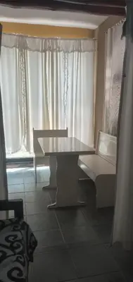 a table and a bench in a room with curtains at Inti Mayu in Villa Cura Brochero