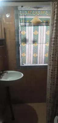 a bathroom with a sink and a window with a curtain at Inti Mayu in Villa Cura Brochero