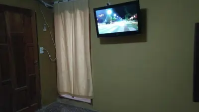a television hanging on a wall next to a window at Inti Mayu in Villa Cura Brochero