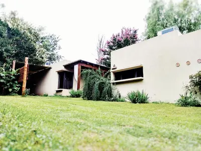 a white house with a grass yard at San Antonio Querido in Villa Carlos Paz