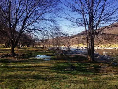 a river in a field with trees and a body of water at San Antonio Querido in Villa Carlos Paz