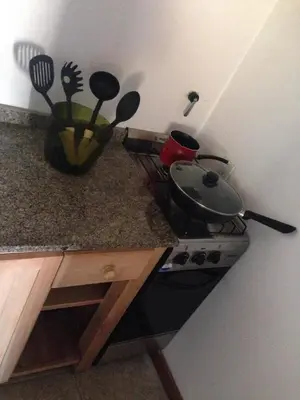 a kitchen with a stove with a pan and utensils at San Antonio Querido in Villa Carlos Paz