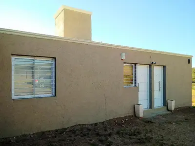 a building with a door and a window at Departamento Pircas in Tanti