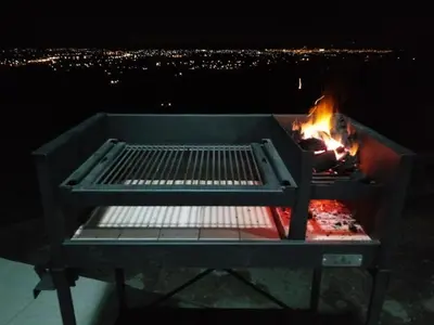 a grill with a fire in it at night at Departamento Pircas in Tanti