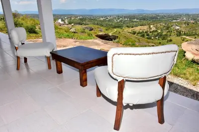 two chairs and a table on a balcony with a view at Departamento Pircas in Tanti