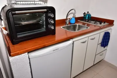 a small kitchen with a sink and a microwave at Departamento Pircas in Tanti
