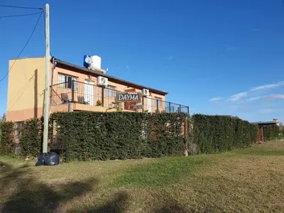 a building with a hedge in front of a house at Cabañas DAYMA in Trapiche