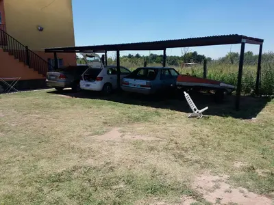 a yard with two cars parked under a shed at Cabañas DAYMA in Trapiche