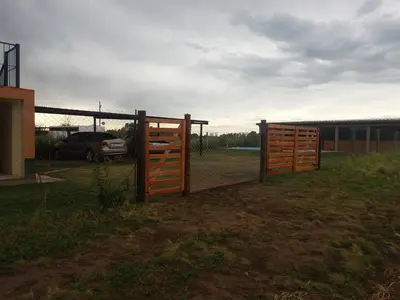 a wooden fence with a gate in a field at Cabañas DAYMA in Trapiche