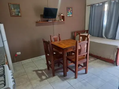 a dining room with a table and chairs and a bed at Cabañas DAYMA in Trapiche