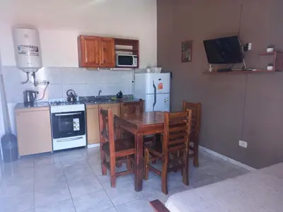 a kitchen with a table and chairs and a refrigerator at Cabañas DAYMA in Trapiche