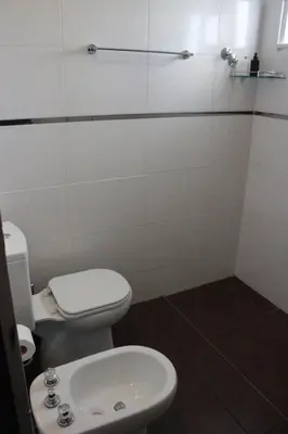 a bathroom with a toilet and a sink at Villa Cabrera Apart and Suites in Cordoba