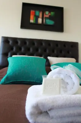 a pile of towels sitting on top of a bed at Villa Cabrera Apart and Suites in Cordoba