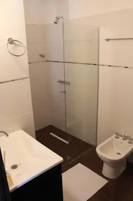 a bathroom with a shower and a sink and a toilet at Villa Cabrera Apart and Suites in Cordoba