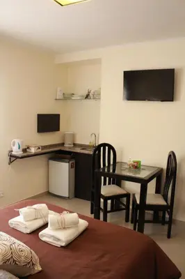 a room with a table and a table and a kitchen at Villa Cabrera Apart and Suites in Cordoba
