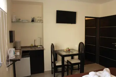 a small table and chairs in a room with a kitchen at Villa Cabrera Apart and Suites in Cordoba
