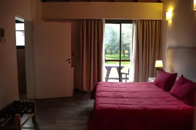 a hotel room with a red bed and a window at Posada Piedras Del Sol in Villa General Belgrano
