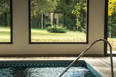a swimming pool with a window in a house at Posada Piedras Del Sol in Villa General Belgrano