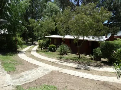 a walkway in front of a house with trees at Cabañas 
