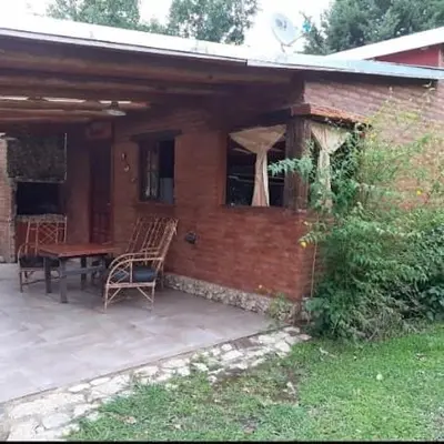 a brick house with a table and chairs on a patio at Cabañas 