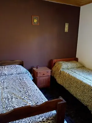 a bedroom with two beds and a night stand at Cabañas 