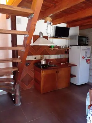 a small kitchen with a stove and a refrigerator at Cabañas 