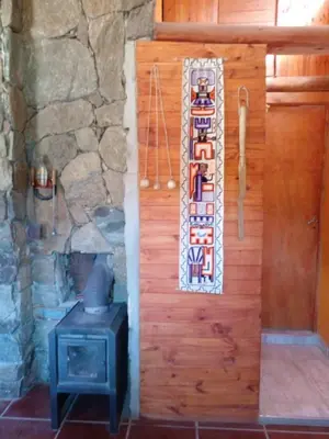 a wooden door with a mosaic on it next to a stove at Cabañas 