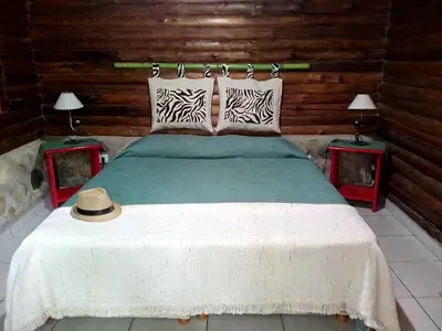 a bedroom with a large bed with two tables at Mainame Traslasierra in Los Hornillos