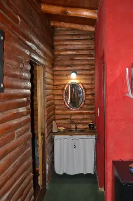 a bathroom with a sink in a log cabin at Mainame Traslasierra in Los Hornillos