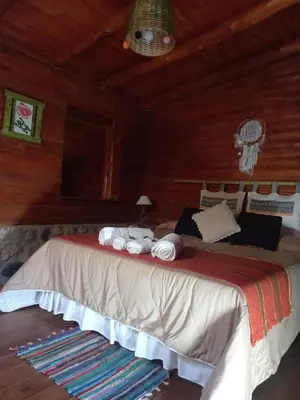 a bedroom with a large bed in a cabin at Mainame Traslasierra in Los Hornillos