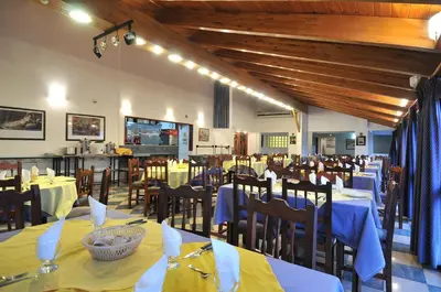 a dining room with tables and chairs with blue table cloth at Hotel El Cid in Villa Carlos Paz