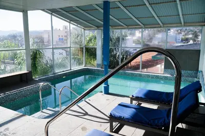 a swimming pool with a chair next to a swimming poolvisor at Hotel El Cid in Villa Carlos Paz