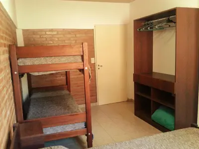 a room with a bunk bed and a mirror at Departamentos Flor de Loto in Mina Clavero