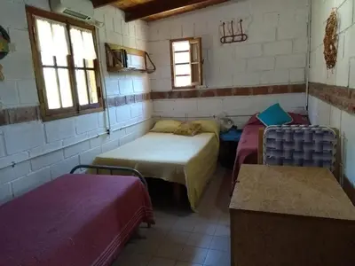 a room with two beds in a room with windows at Aike Cabañas de Montaña in San Clemente
