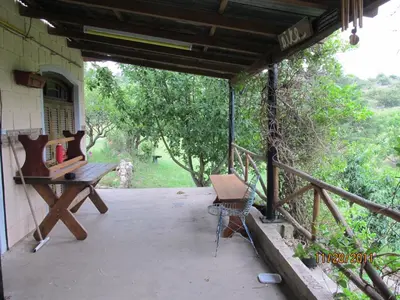 a porch of a house with a table and a bench at Aike Cabañas de Montaña in San Clemente