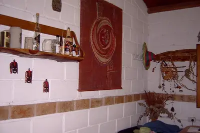 a kitchen with white tiled walls and a shelf at Aike Cabañas de Montaña in San Clemente