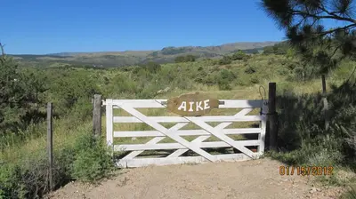 a gate with the word aike painted on it at Aike Cabañas de Montaña in San Clemente