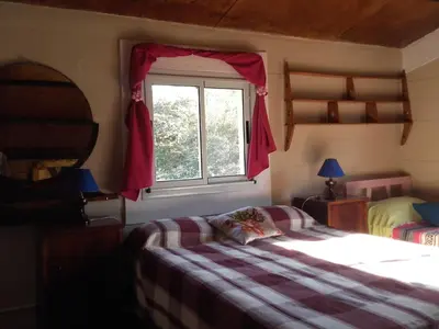 a bedroom with a bed and a window at Aike Cabañas de Montaña in San Clemente