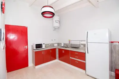 a kitchen with red cabinets and a white refrigerator at Colores Rio Cuarto in Río Cuarto