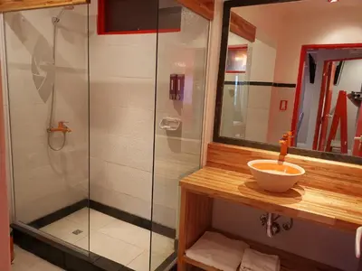 a bathroom with a glass shower and a sink at Colores Rio Cuarto in Río Cuarto