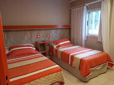 a bedroom with two beds and a window at Colores Rio Cuarto in Río Cuarto