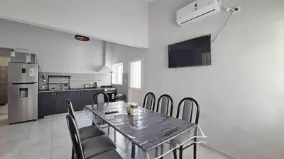 a dining room with a table and chairs and a kitchen at Colores Rio Cuarto in Río Cuarto