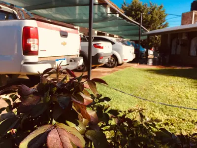 a group of rvs parked in a yard with a bush at Aoniken Cabañas in Villa Cura Brochero