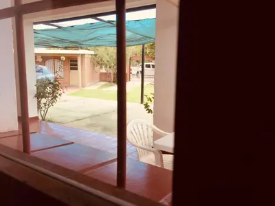 a view of a porch with a chair and an umbrella at Aoniken Cabañas in Villa Cura Brochero